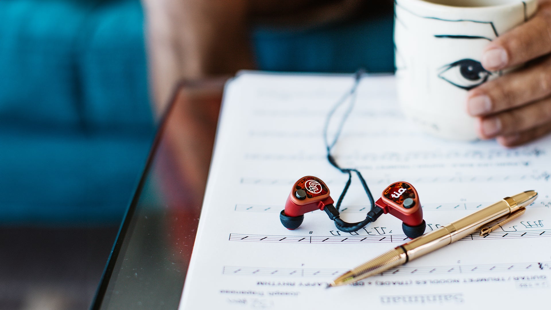 64audio iems on top of sheet music with gold pen